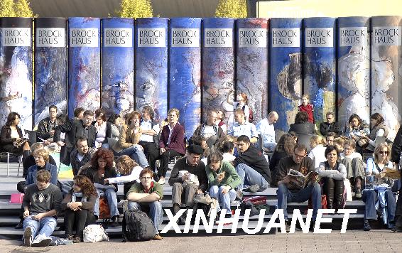 2007年10月13日,在德国法兰克福书展上,参观者在展会广场上的书籍雕塑前休息。为期5天的第59届法兰克福书展于14日闭幕。法兰克福书展是全球最大的图书展览会之一,今年参展的书籍和相关产品达到38万件。 新华社记者吴晓凌摄